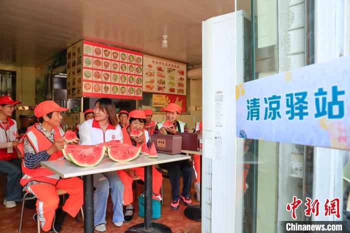 环卫工人在“清凉驿站”吃西瓜。　赵明 摄