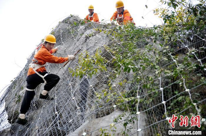 鹰潭工务段景德镇北路桥工区职工们攀爬在江西省婺源县赋春梅山崖上。　卓忠伟 摄