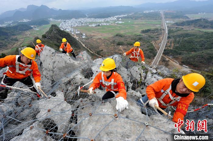 鹰潭工务段景德镇北路桥工区职工们攀爬在江西省婺源县赋春梅山崖上。　卓忠伟 摄