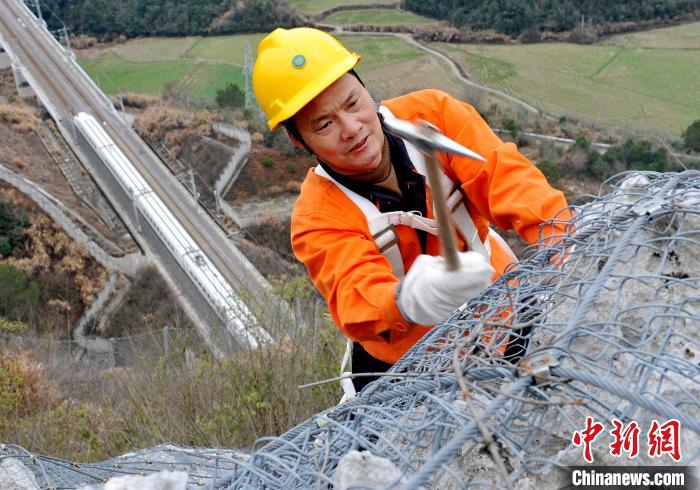 鹰潭工务段景德镇北路桥工区职工们正在江西省婺源县赋春梅山崖上，检查崖壁上的危石是否松动。　卓忠伟 摄