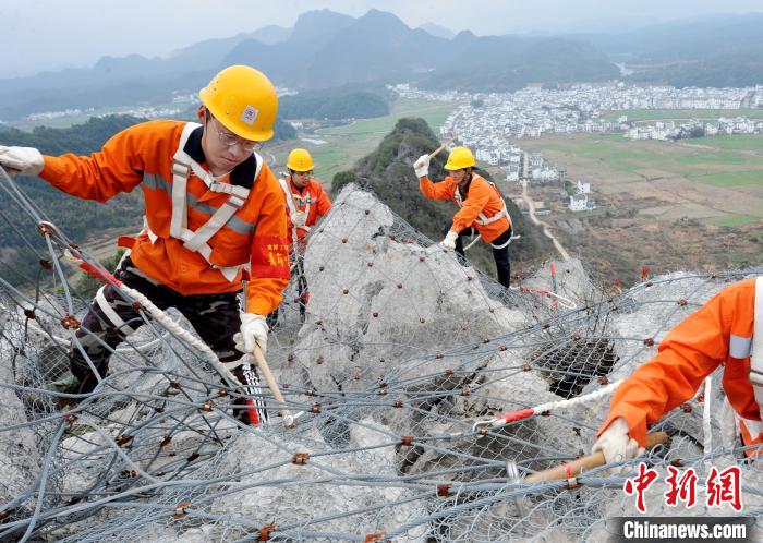 鹰潭工务段景德镇北路桥工区职工们攀爬在江西省婺源县赋春梅山崖上。　卓忠伟 摄