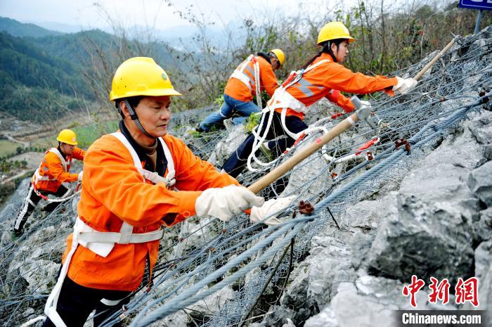 鹰潭工务段景德镇北路桥工区职工们攀爬在江西省婺源县赋春梅山崖上。　卓忠伟 摄