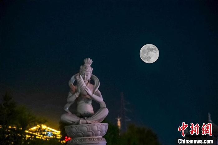 5月26日深夜，一轮超级圆月悬挂在敦煌党河风情线上。(图片为双重曝光)。　王斌银 摄