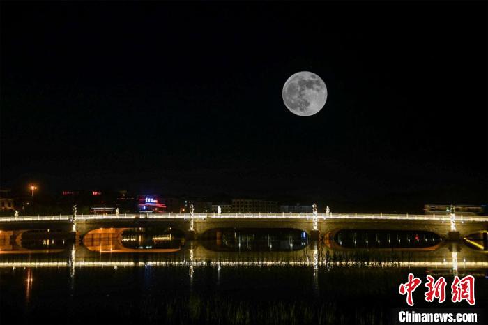 5月26日深夜，一轮超级圆月悬挂在敦煌党河风情线上。(图片为双重曝光)。　王斌银 摄