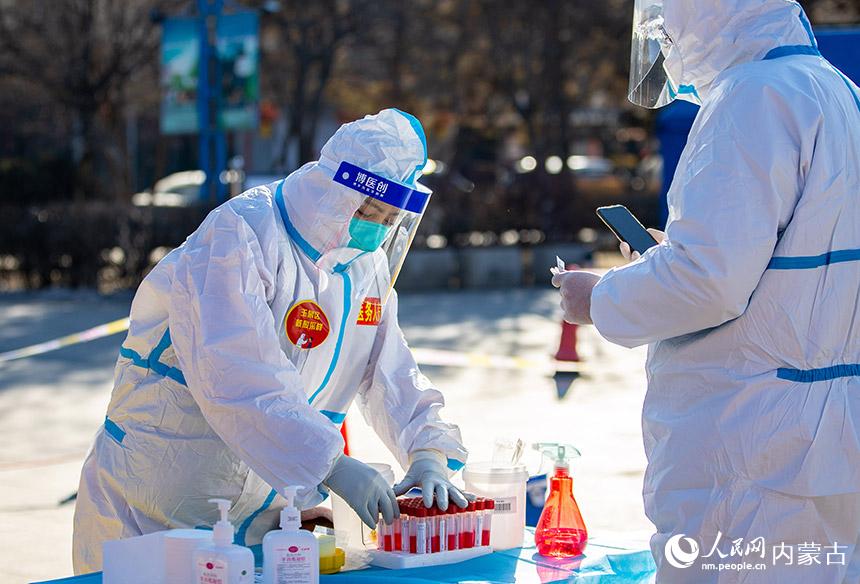 在呼和浩特市玉泉区小召街道五塔寺广场临时核酸采样点，医务人员在整理采样管。丁根厚摄