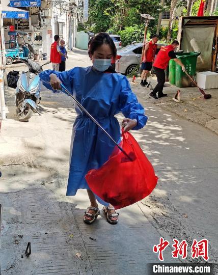 霞浦县金山小区，志愿者清理路面垃圾。　王兰 供图
